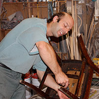 Patrick Delaquis working on an antique wooden chair